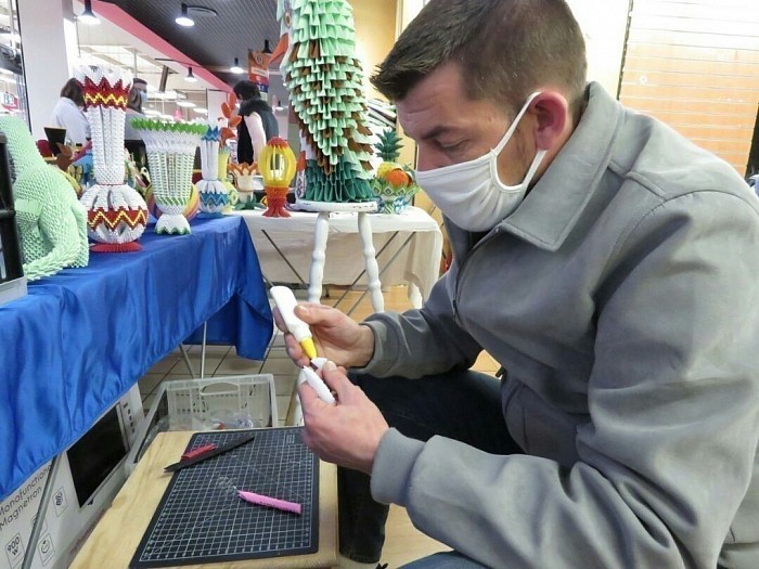 Mr Violette Arnaud, lors de  l'assemblage et du montage d'un article,  sur son stand d'exposition à Carrefour Market de Pont Audemer décembre 2020